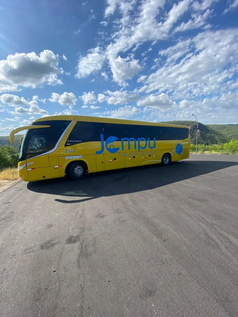Ônibus executivo rodoviário amarelo da frota Jompu, visto de perfil