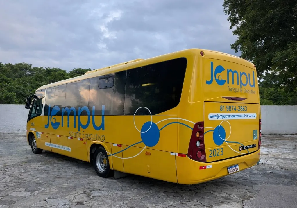Micro-ônibus executivo amarelo da frota Jompu com a identidade visual da empresa